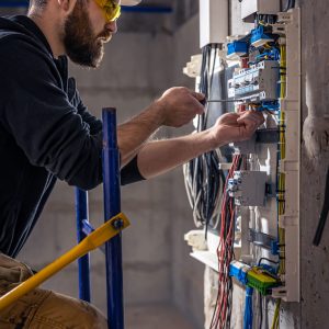 um-eletricista-trabalha-em-uma-mesa-telefonica-com-um-cabo-eletrico-de-conexao (1) um-eletricista-trabalha-em-uma-mesa-telefonica-com-um-cabo-eletrico-de-conexao (1)